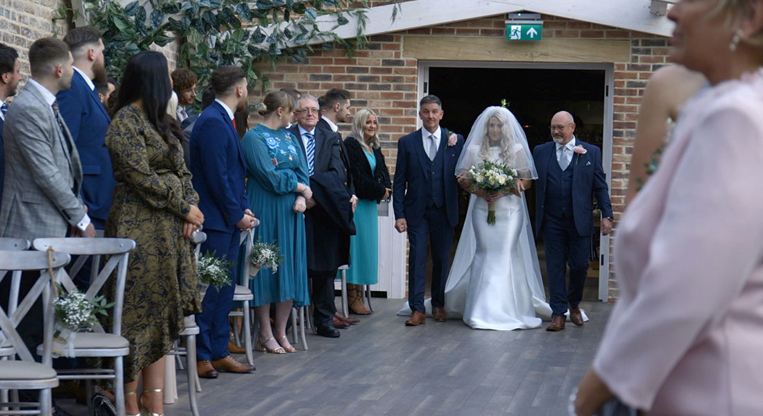 Video still of Hannah walking down the aisle on her wedding day