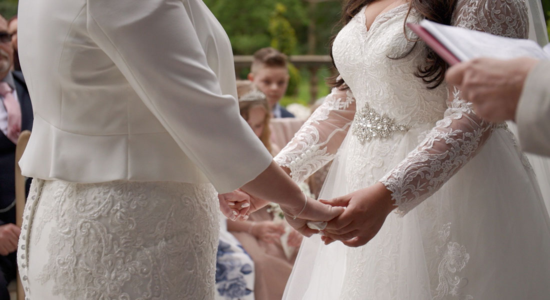 Still of the brides holding hands at the ceremony from Sheryl and Jodies's wedding filmed in Staffordshire by Wedding Stories by Hannah Quinn